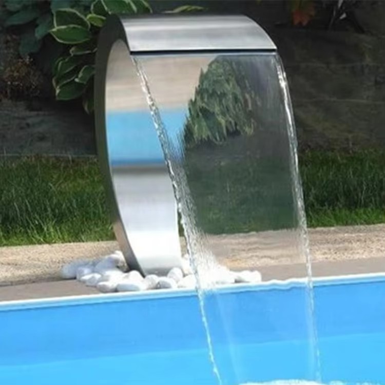 Cascada curva de acero inoxidable junto a piscina exterior